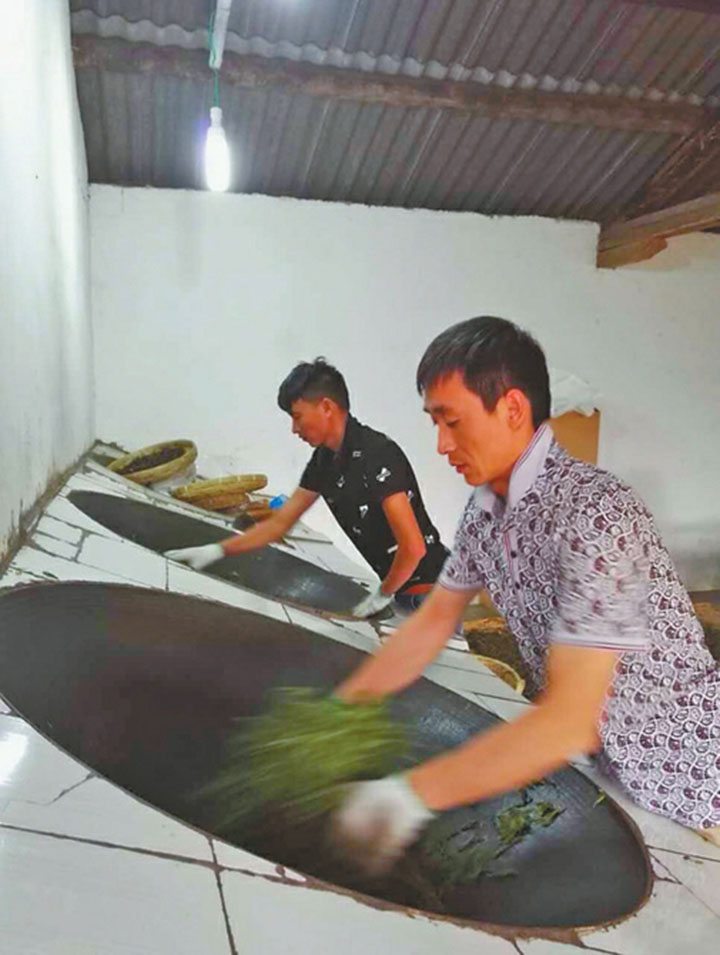 炒茶师傅在炒制普洱茶。