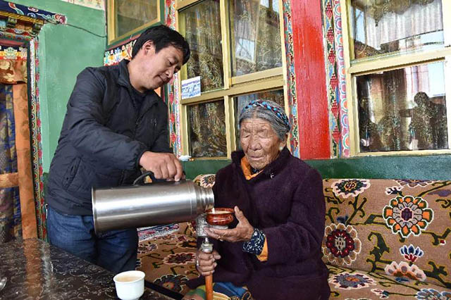 边巴仓决的孙子南木加为老人倒酥油茶