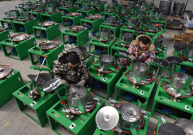 湖南省双峰县农家宝机械科技有限责任公司车间的工人在加紧组装揉茶机