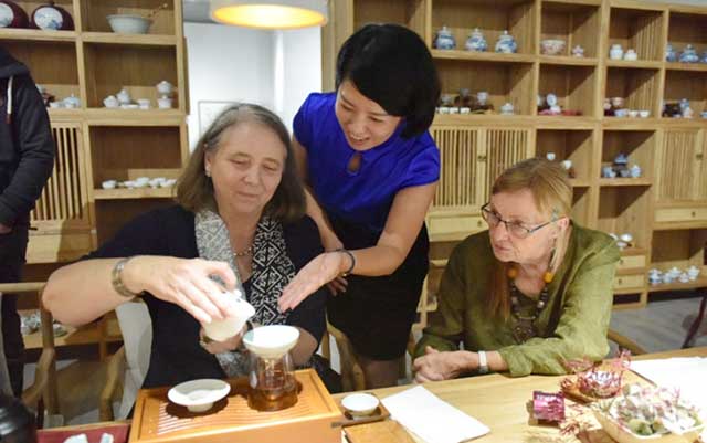 时任武夷山茶叶局局长邓崇慧在中国茶馆向德国茶友传授武夷山岩茶泡制方法