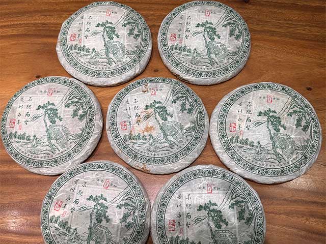 图为普洱茶厂永年九九绿古乔青饼